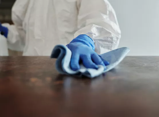 a person in ppe wiping down a surface