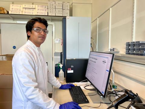 A scientist stands at a computer