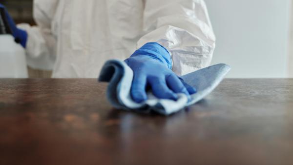 a person in ppe wiping down a surface